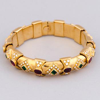 RANNEKORU, viistehiotut smaragdit ja rubiinit, briljanttihiotut timantit, 18K kultaa.