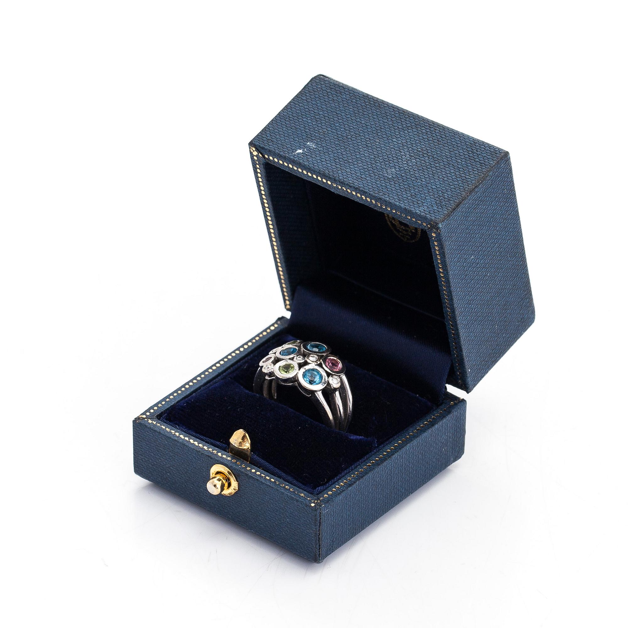 Cassandra Goad, sormus, "Cirkel", 18K valkokultaa, timantteja noin 0.08 ct ja monivärisiä jalokiviä. Lontoo.