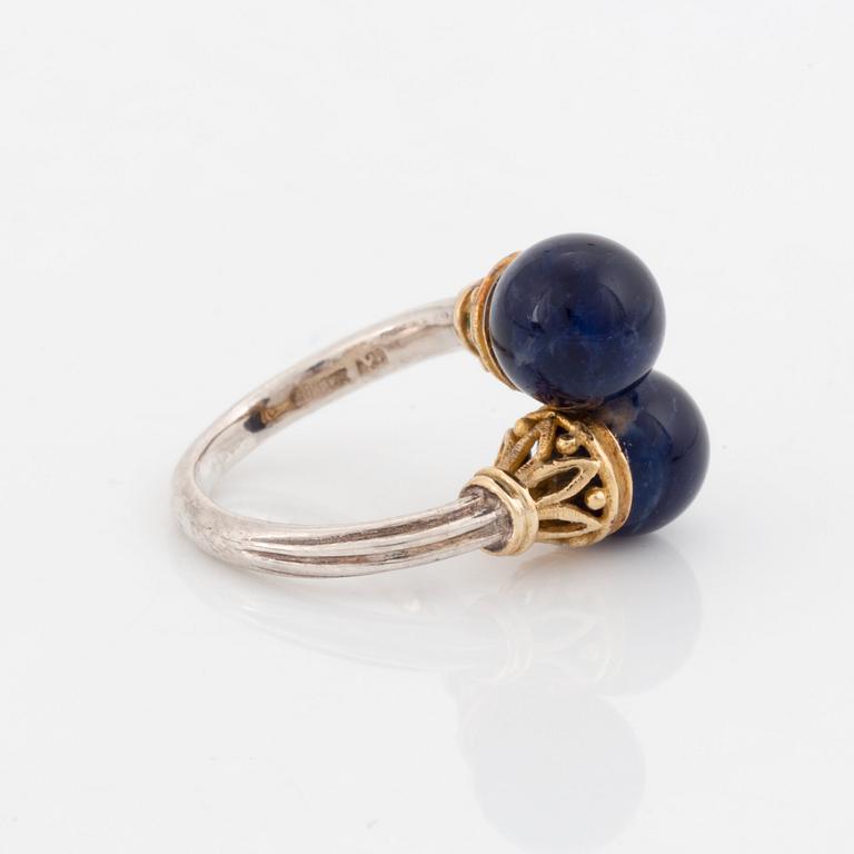 An Ilias Lalaounis demi parure comprising a necklace, a bracelet and a ring in silver and 18K gold set with sodalite.