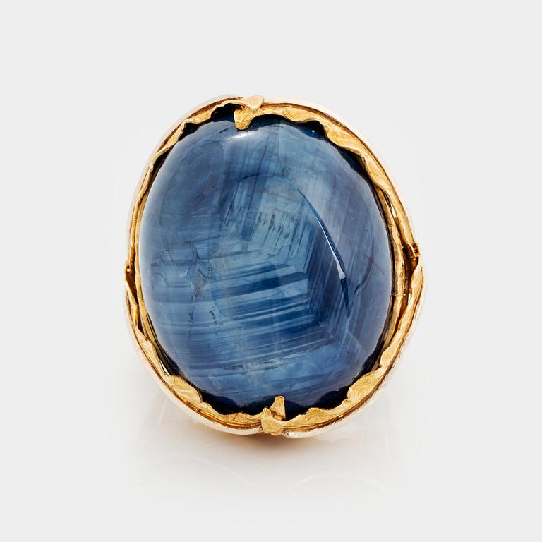 A Tina Karlsson ring in 18K gold set with a cabochon-cut sapphire.