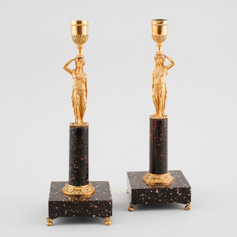 A pair of late gustavian early 19th century porphyry and ormolu candlesticks.