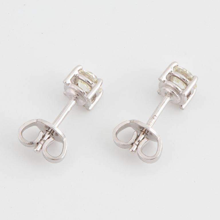 A pair of brilliant cut diamond earrings.