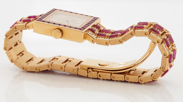 A Bulgari wristwatch in 18K gold set with step-cut rubies and round brilliant-cut diamonds.