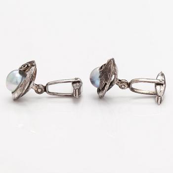 A pair of silver cufflinks with cultured baroque/Akoya pearls.