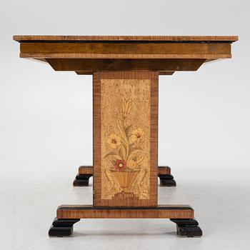 A 1930's birch and rosewood-veneered dining table.