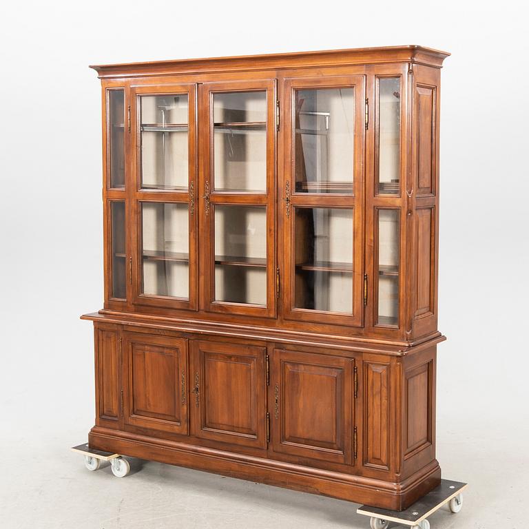 A stained walnut display cabinet from the first half of the 20th century.