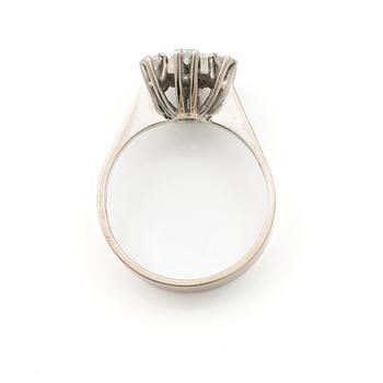 Ring 18K vitguld med en cabochonslipad smaragd och runda briljantslipade diamanter, Stockholm 1976.