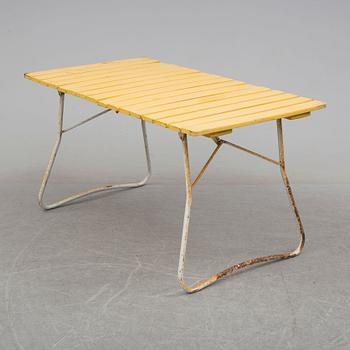 A mid 20th century garden table and three chairs.