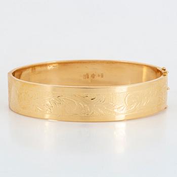 An 18K gold bangle.