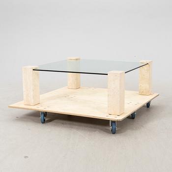 A late 20th century glass and travertin coffee table.