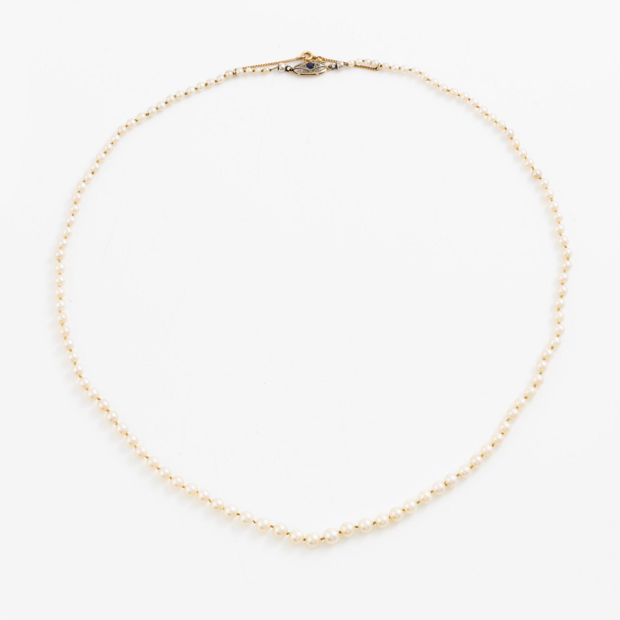 Necklace of cultured pearls with a clasp in 18K gold set with a blue stone.