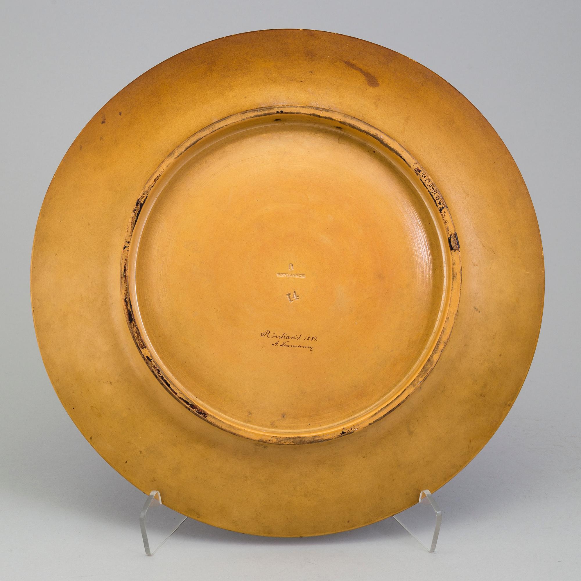 A wall plate by Adolf Neumann, Rörstrand, signed on verso 1884.