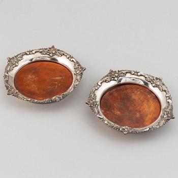 A pair of silver plate and wood coasters, circa 1900.