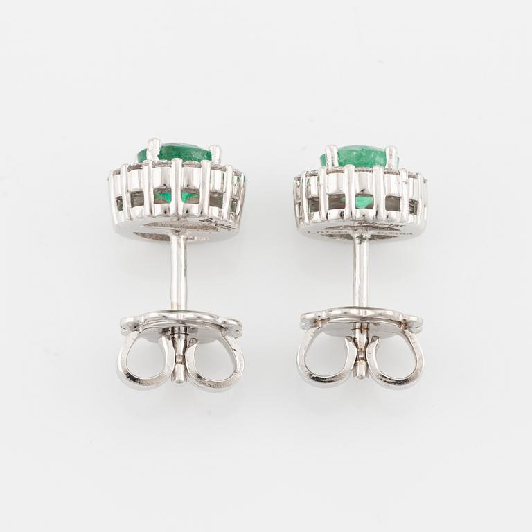 A pair of 18K gold earrings with faceted emeralds and round brilliant-cut diamonds.