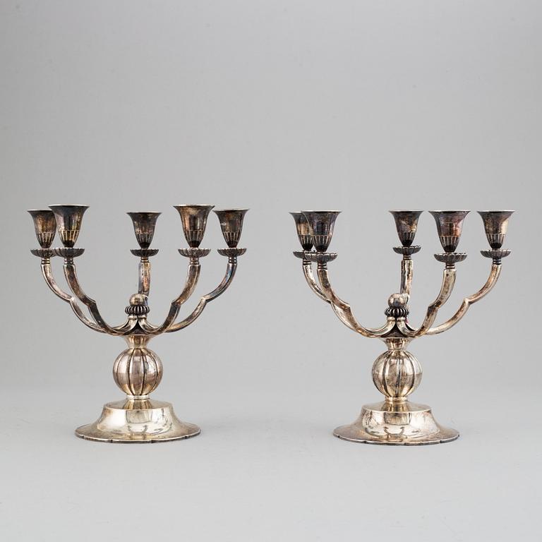 A pair of Swedish Grace silver candelbar for        five candles, mark of GAB, Stockholm, 1929.