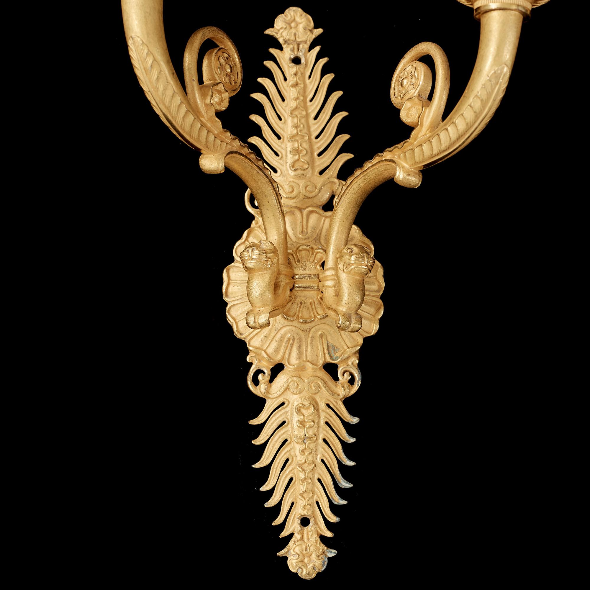 A pair of Empire early 19th century gilt bronze two-light wall-lights.
