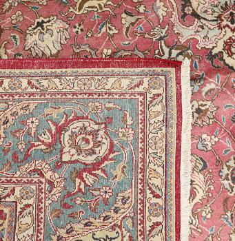 A Tabriz carpet, signed, c. 395 x 298 cm.