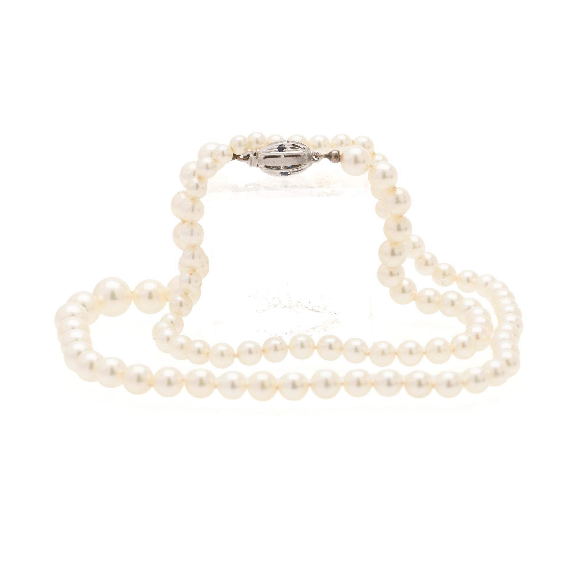 Necklace of cultured graduated pearls with an 18K white gold and sapphire clasp.