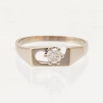 An 18K white gold solitaire ring set with a round brilliant-cut diamond.