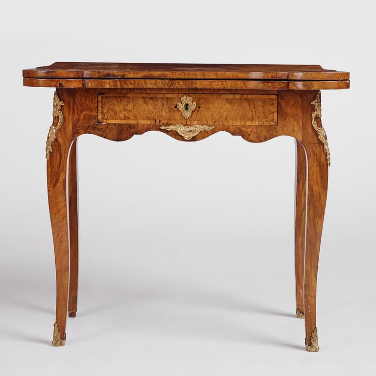 A Swedish walnut-veneered and gilt-brass mounted rococo games table, later part of the 18th century.