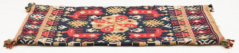 A double-interlocked tapestry carrige cushion from Scania, ca 99 x 49 cm, first half of the 19th century.