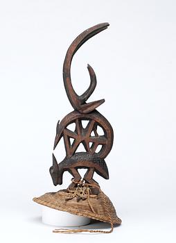 1134. HUVUDPRYDNAD på hatt. Tshiwara (stiliserad antilop) på annat djur. Trä. Bambara-stammen. Mali ca 1930-1940. Höjd 39,5 cm inklusive hatt.