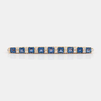 An 18K gold brooch set with step-cut sapphires and old-cut diamonds.