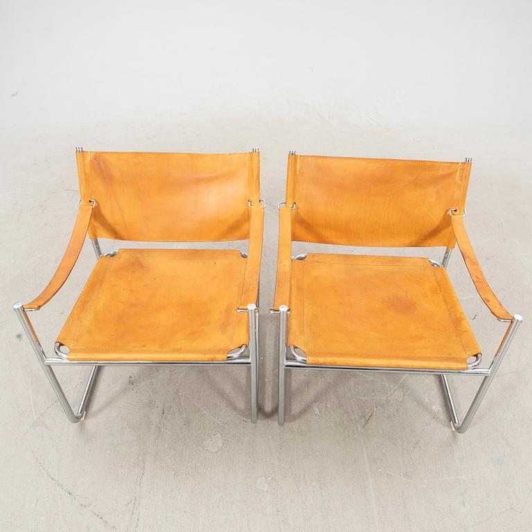 A pair of metal and leather arm chairs by DUX.