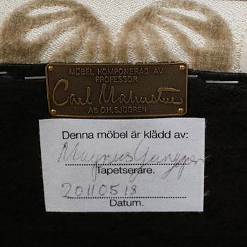 An armchair named "Rundrygg", designed by Carl Malmsten and made by OH Sjögren in 2011.