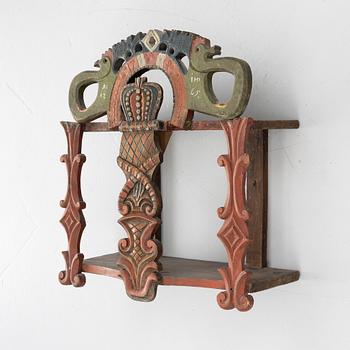 A Swedish carved and painted folk art shelf from Hälsingland, 18th / 19th century.