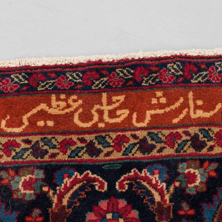 A CARPET, semi-antique Mashad, signed, around 360 x 320 cm.