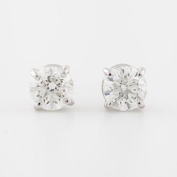 A pair of brilliant cut diamond earrings.