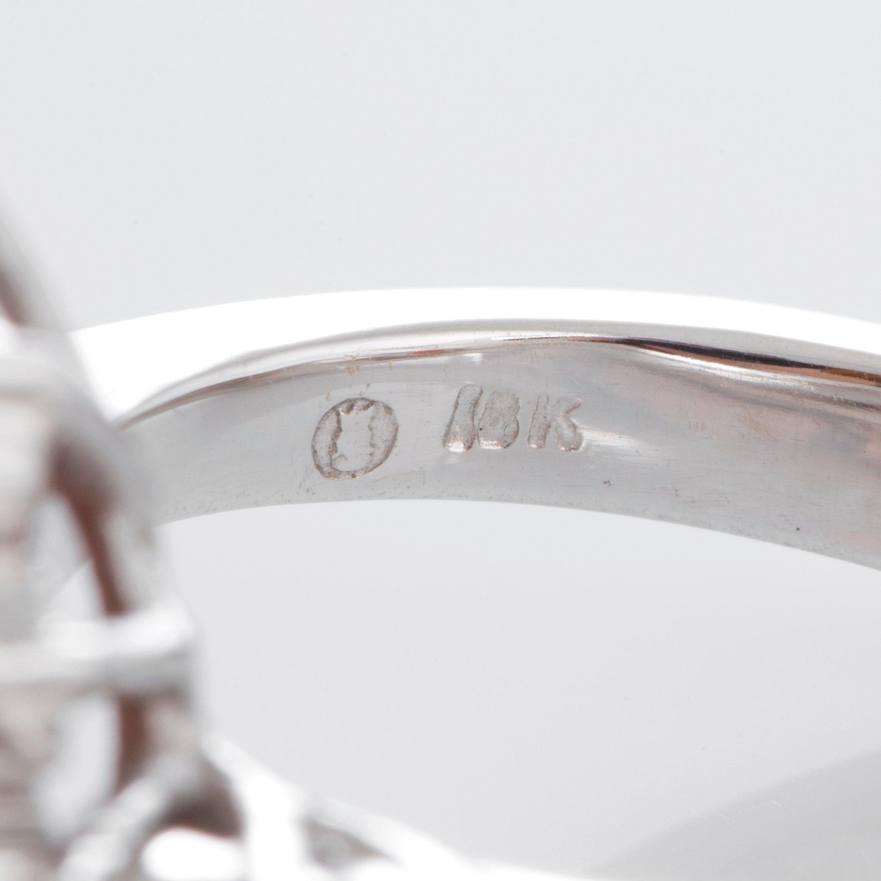 Ring med en fasettslipad spessartingranat samt runda briljantslipade diamanter.