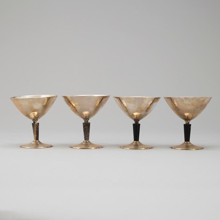 A silver plated and bakelite shaker and four glasses, mid 20th century.