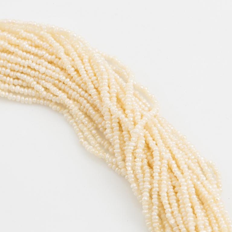 A pearl necklace with an 18K gold clasp set with round brilliant-cut diamonds.