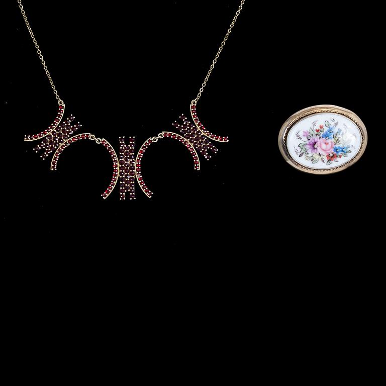 HALSSMYCKE OCH BROSCH, förgyllt silver med granater resp målat porslin. Brosch Finland, 1951.