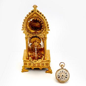 A mid 1800s gilded bronze pocket watch stand and pocket watch.