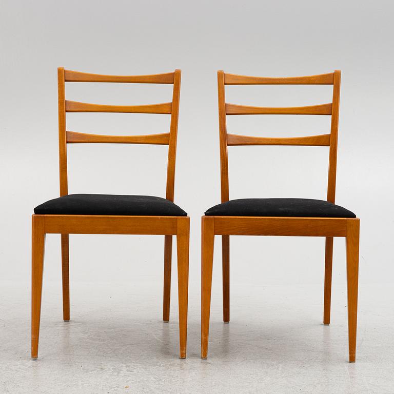 A dining table with four chairs, mid 20th century.