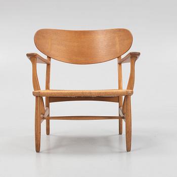 Hans J. Wegner, a model 'CH 22' armchair, Carl Hansen & Son, Odense, Denmark, mid 20th Century.