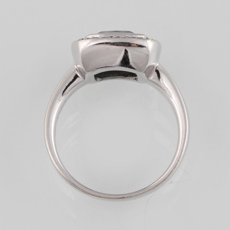 RING, 18K vitguld med fasettslipad blå topas samt 36 briljantslipade diamanter, ca 0.18 ct. Vikt 8,2 gram.