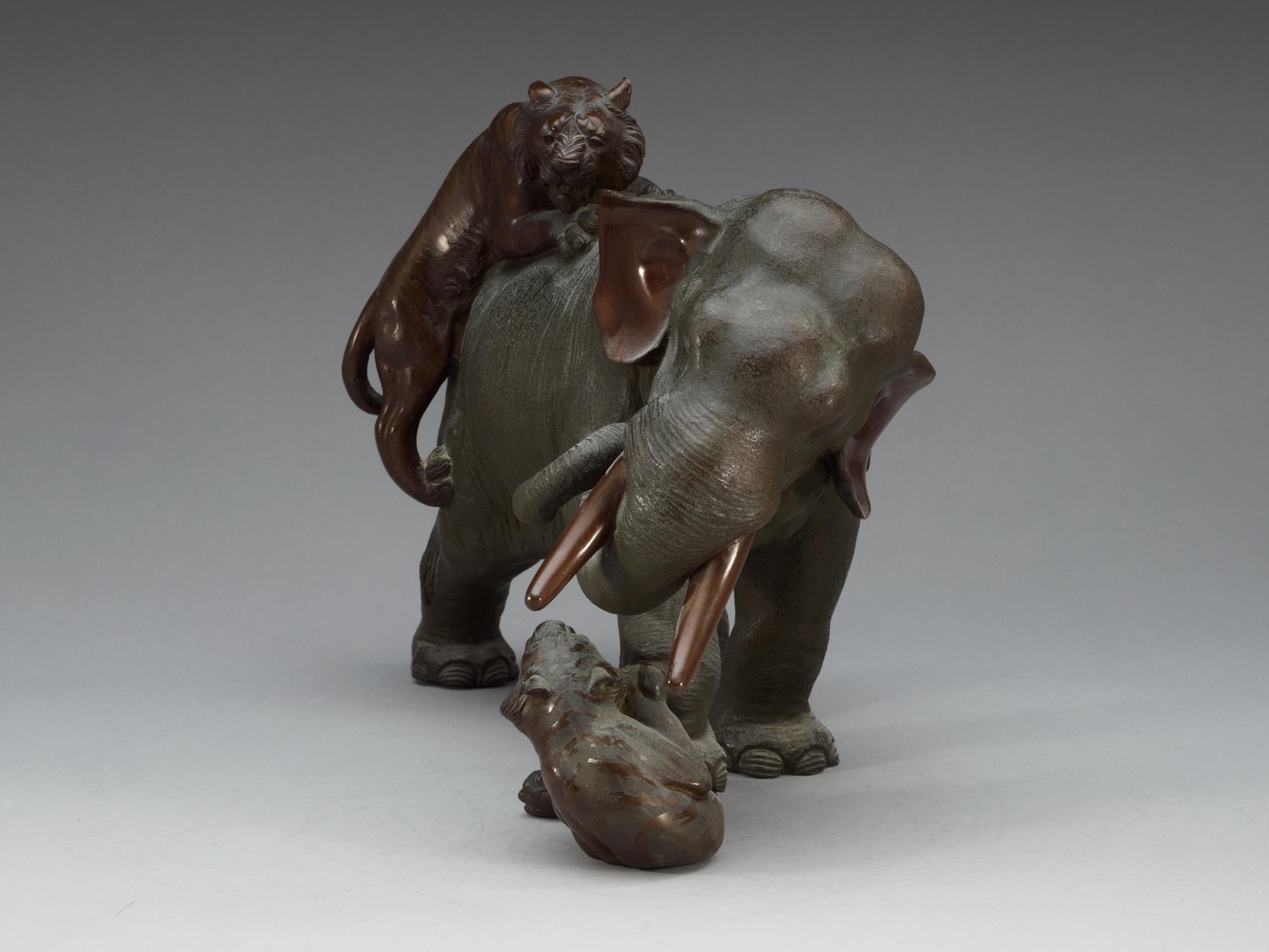 A large Japanese bronze sculpture of an elephant attacked by tigers, with seal mark, Meiji, circa 1900.