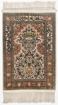 A silk Hereke rug, c. 77 x 53 cm.