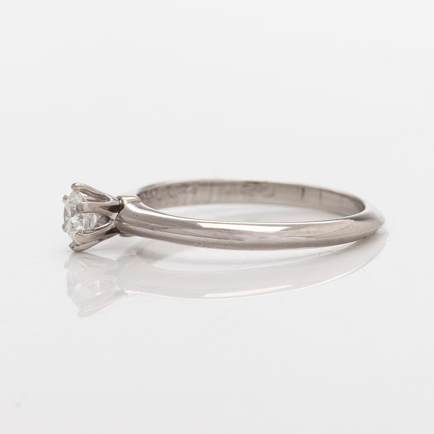 Tiffany & Co, sormus, platinaa, briljanttihiottu timantti n. 0.23 ct kaiverruksen mukaan. Sertifikaatilla.
