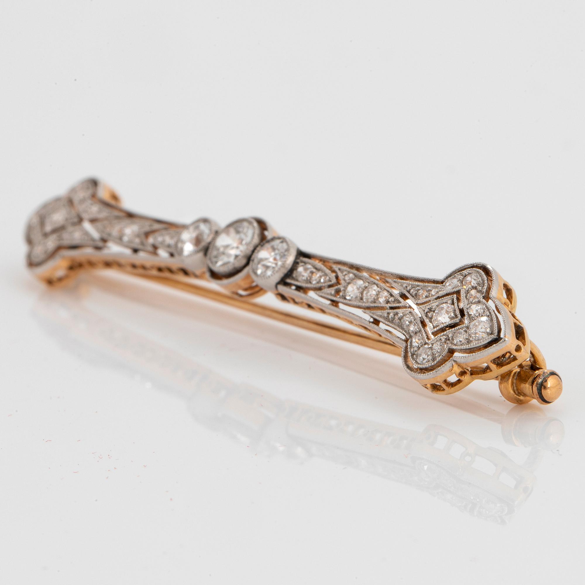 A platinum and 18K gold brooch set with old-cut diamonds with a total weight of ca 1.25 cts.