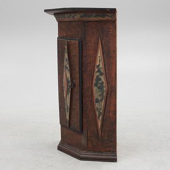 A corner cabinet, 18th Century.