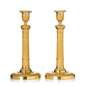 121. A pair of French Empire gilt-bronze candlesticks, early 19th century.