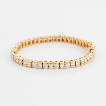 An 18K gold bracelet set with round brilliant-cut diamonds.