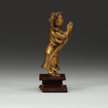 A gilt bronze figurine of a standing boy, Ming dynasty, 17th century.