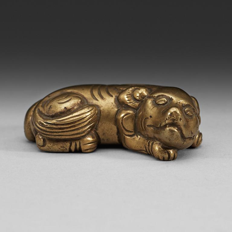 A bronze paper-weight modeled as a reclining lion, Qing dynasty, presumably 18th Century.