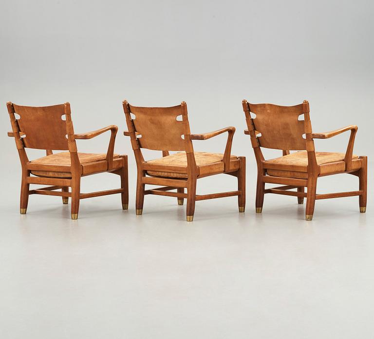 SCANDINAVIAN MODERN, a set of three mid 20th century mahogany and brown leather easy chairs.